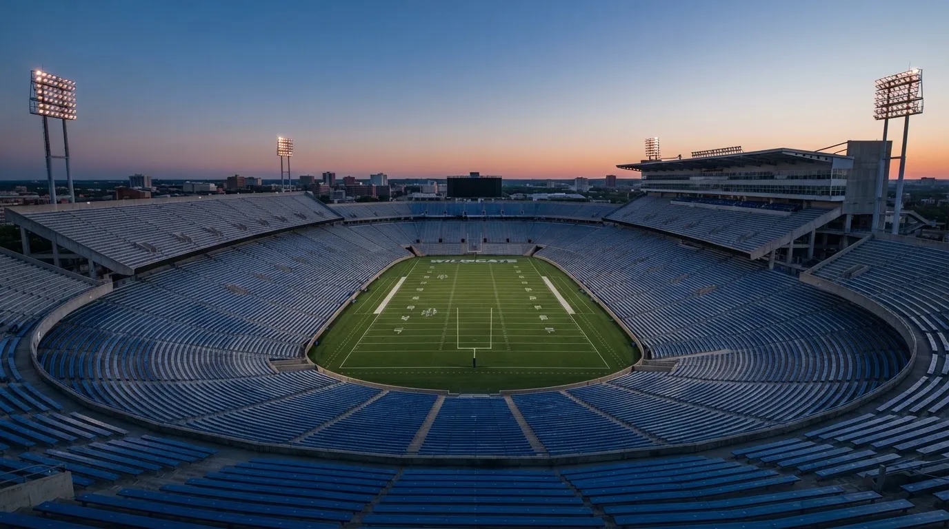 An empty football stadium with floodlight masts at dusk