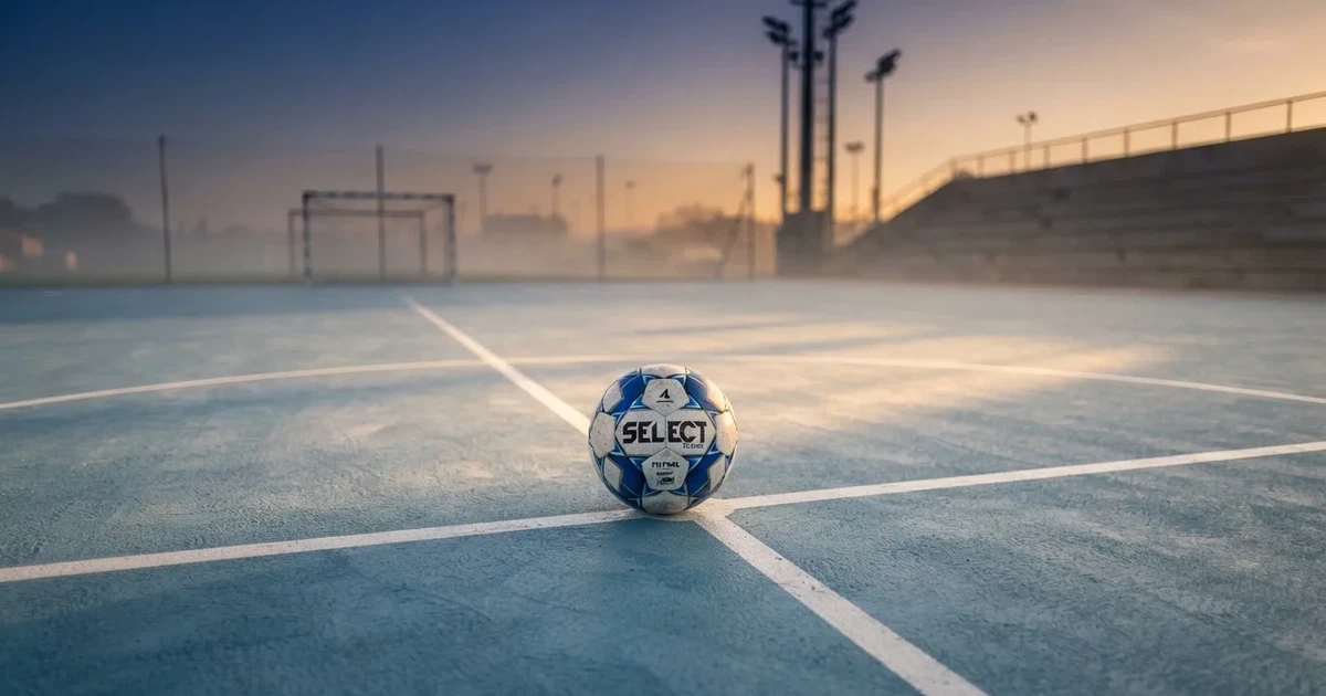A ball on the centre spot of a grass pitch in morning light