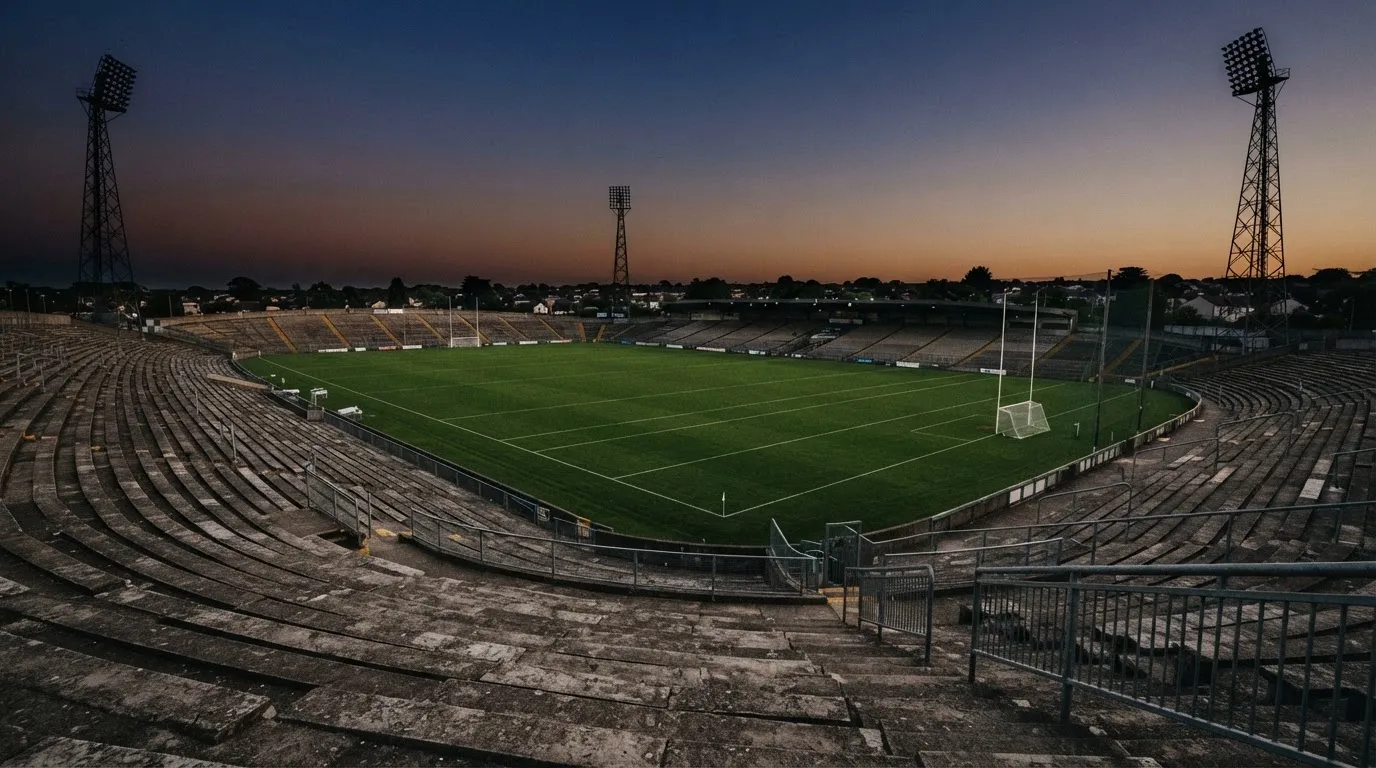 An empty football stadium with floodlight masts at dusk