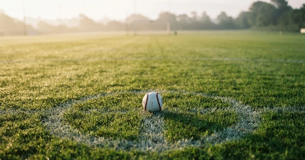 A ball on the centre spot of a grass pitch in morning light