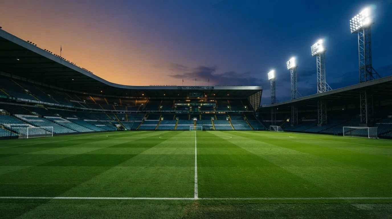 An empty football stadium with floodlight masts at dusk